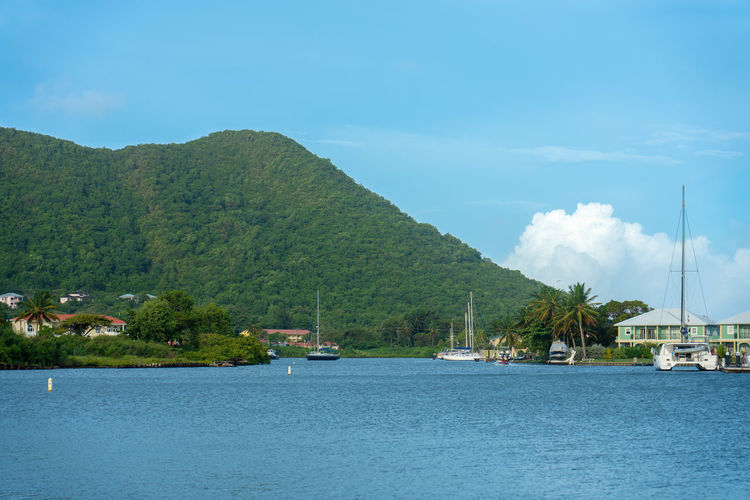 Bay with sailboats, building and mountain in trhe back