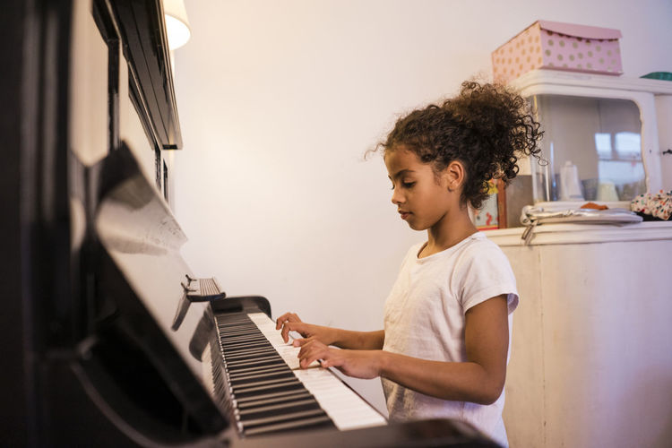 Girl practicing piano at home