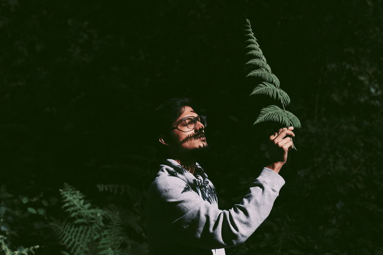 Portrait of person standing by plants