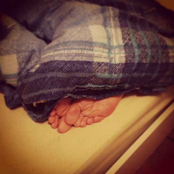 Cropped image of person covered with blanket on bed