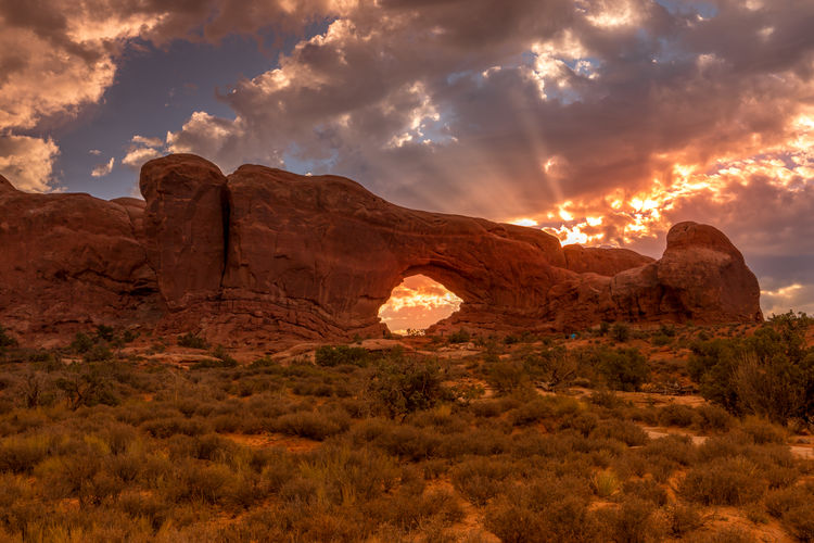 Rock formations on landscape against sky during sunset