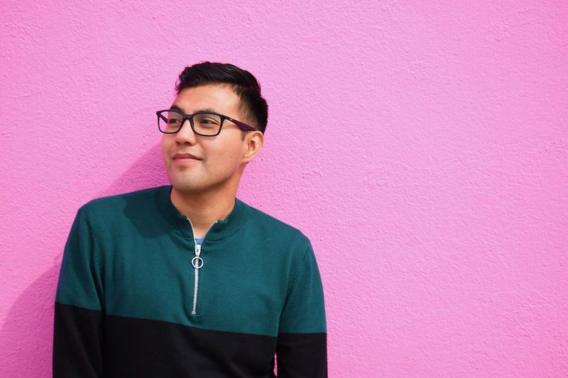 Mid adult man against pink wall