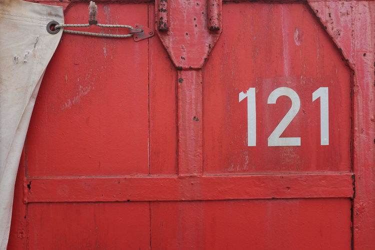 Close-up of numbers on red painted metal