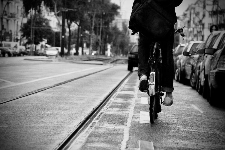 Rear view of person cycling on street