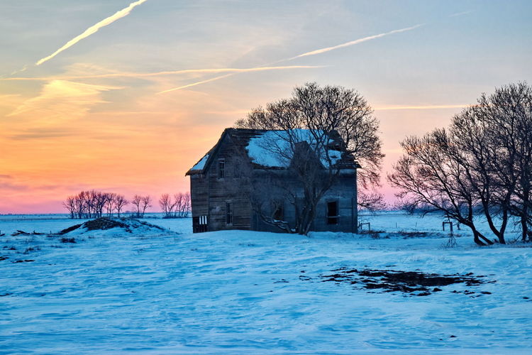 Abandoned house on snow covered land