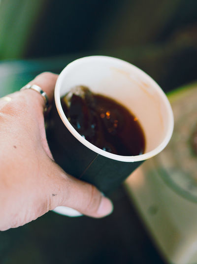 Cropped image of person holding coffee cup