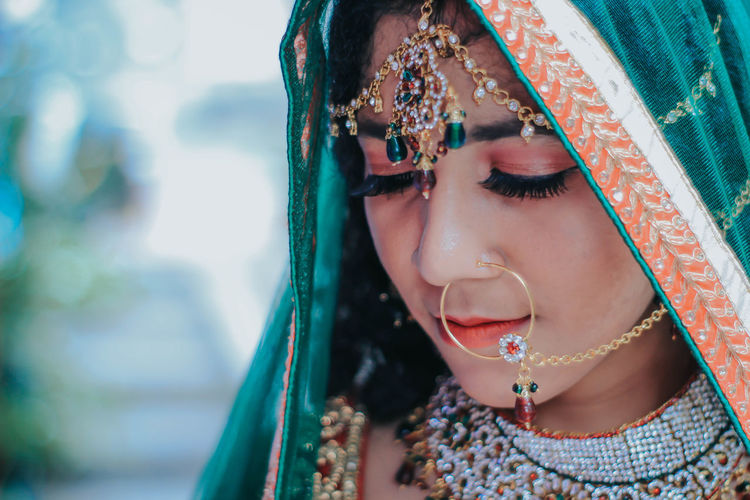 Close-up of woman wearing make-up and jewelry