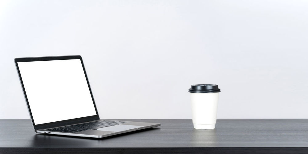 Close-up of laptop on table against white background