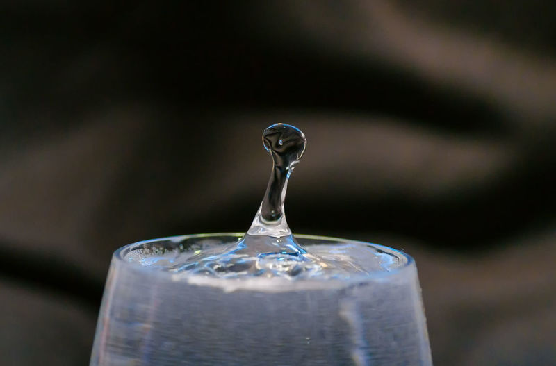 Close-up of splashing water droplet in wineglass