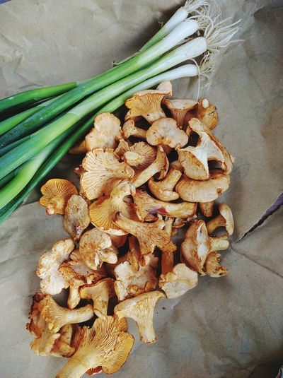High angle view of mushrooms with scallions on paper