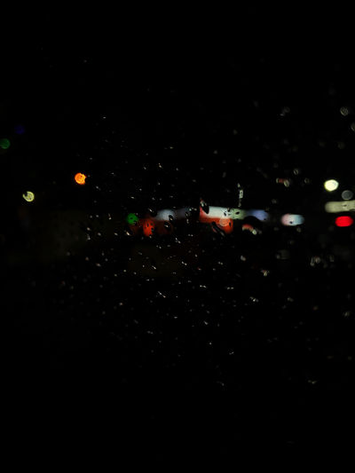Defocused image of illuminated city street during rainy season