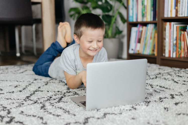 Portrait of boy using laptop at home