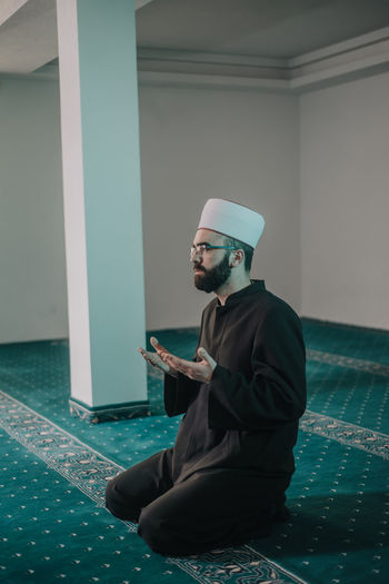 Side view of man praying in mosque