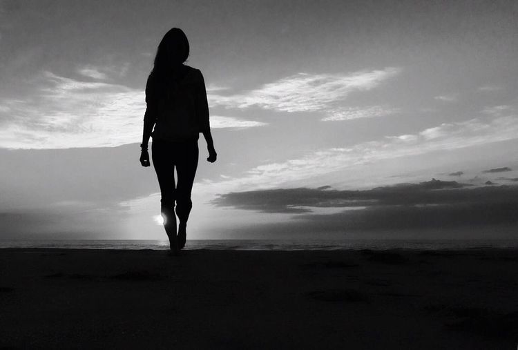 Rear view of silhouette man standing on beach