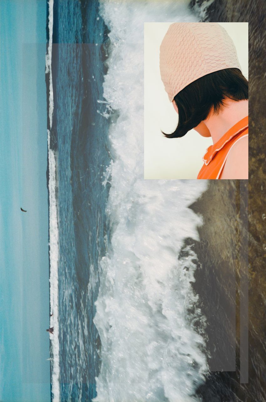 REAR VIEW OF WOMAN STANDING ON BEACH