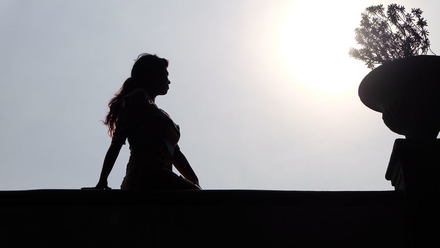 Low angle view of silhouette of woman against sky