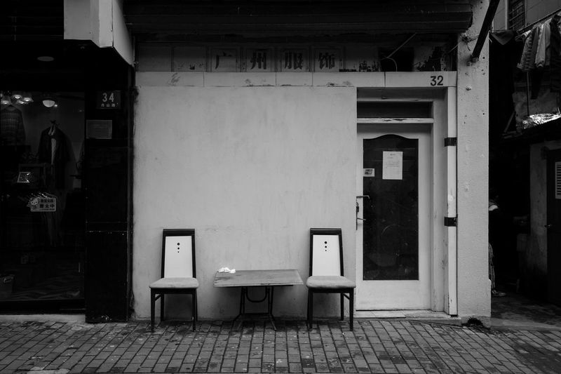Empty chairs and tables outside building
