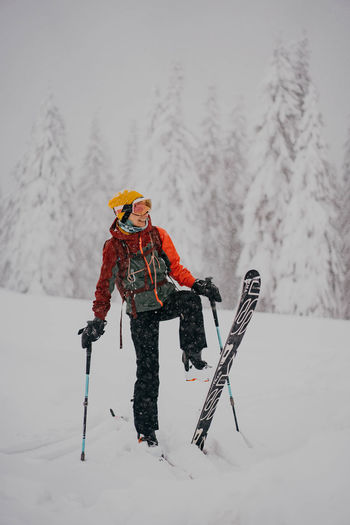 Full length of woman skiing on snow covered field