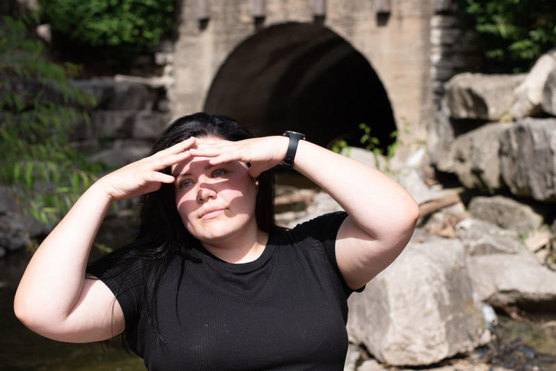 Portrait of woman covering her eyes for shade from the bright sun