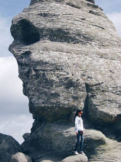 Full length of woman standing against sphinx at bucegi natural park