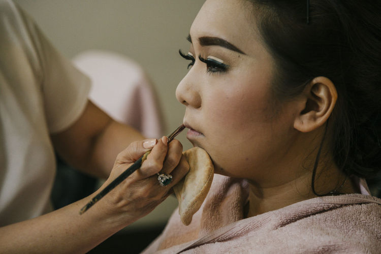 Make-up artist applying lipstick on fashion model