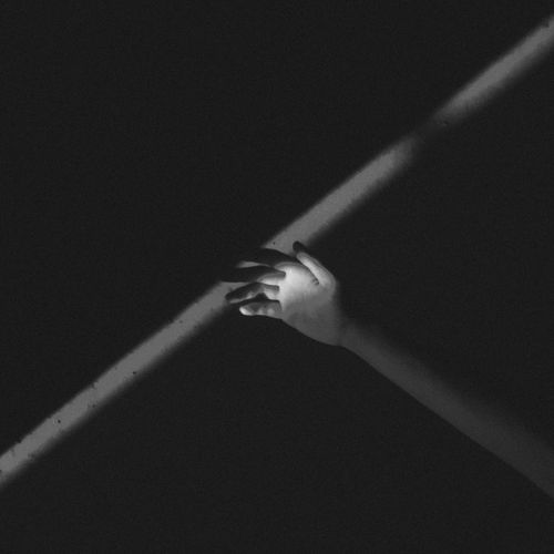 Close-up of hand holding glass over black background