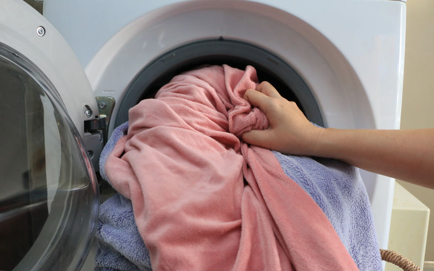 Low section of woman in washing machine