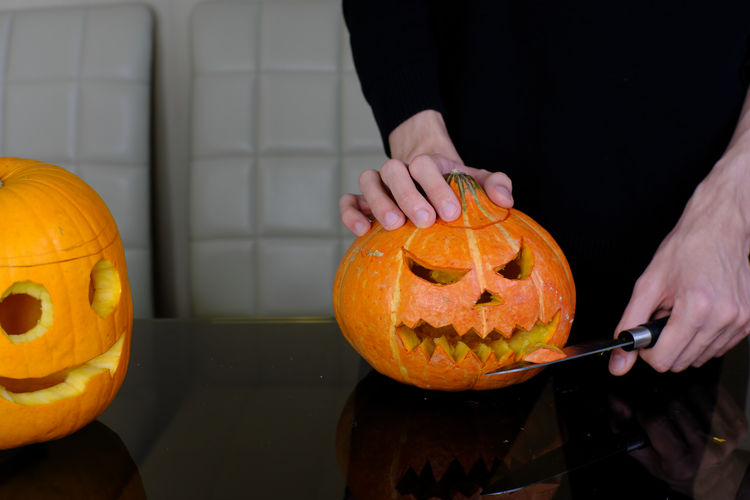 Midsection of man holding pumpkin during halloween
