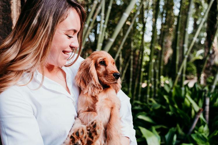 Rear view of woman with dog looking away outdoors
