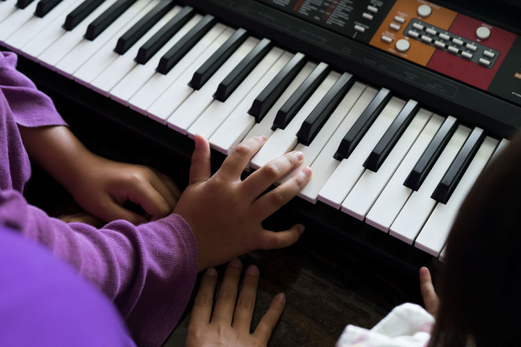 Happy kids playing piano at home