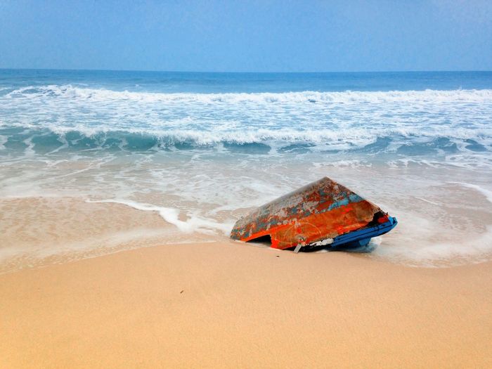 Shipwreck at beach against sky