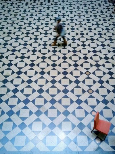 Blurred motion of man walking on tiled floor