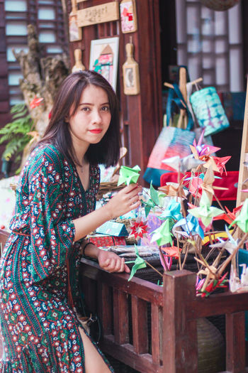 Portrait of woman holding origami at store