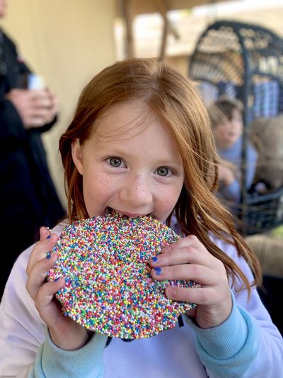 Close-up of red-headed happy girl with a large chocolate freckle 