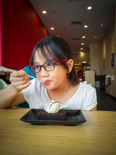 Girl eating ice cream at table