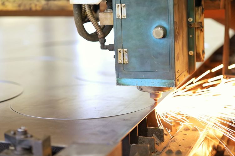 Machine cutting metal in factory