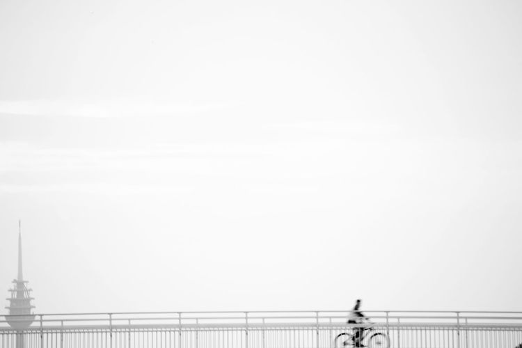 Biker on bridge against clear sky
