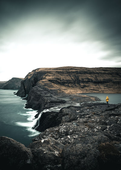 Scenic view of sea and rock formations against cloudy sky