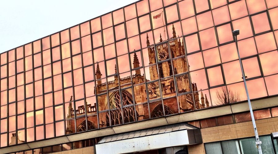 Reflection of cathedral on glass building