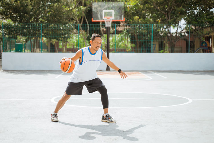 Portrait of man playing with basketball