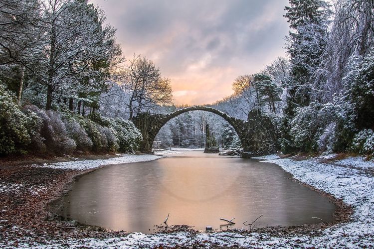 Scenic view of river against sky during winter