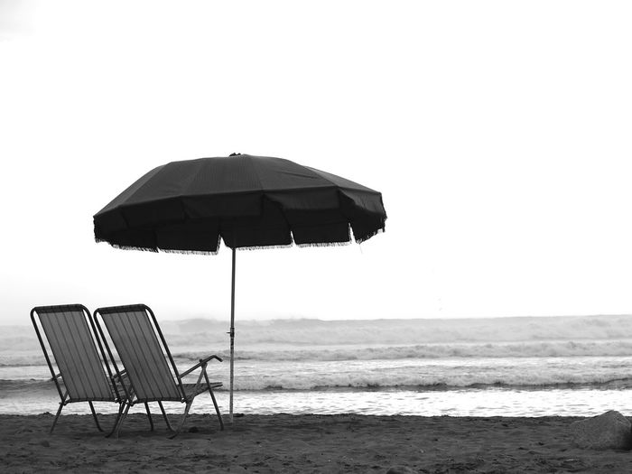 Deck chairs and parasol on sandy beach