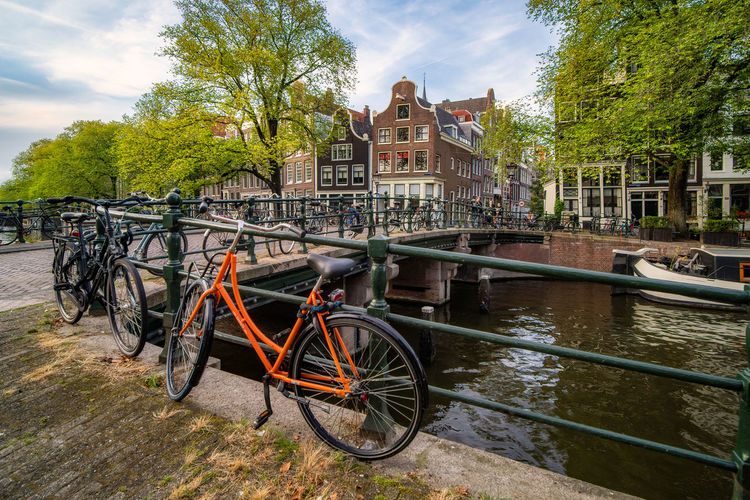 Bicycle by river against buildings in city