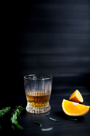 Glass with whiskey and orange.