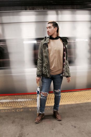 Full length of young man standing at subway station