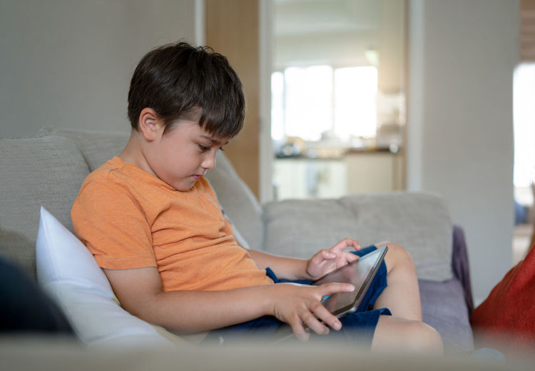 Boy sitting on mobile phone at home