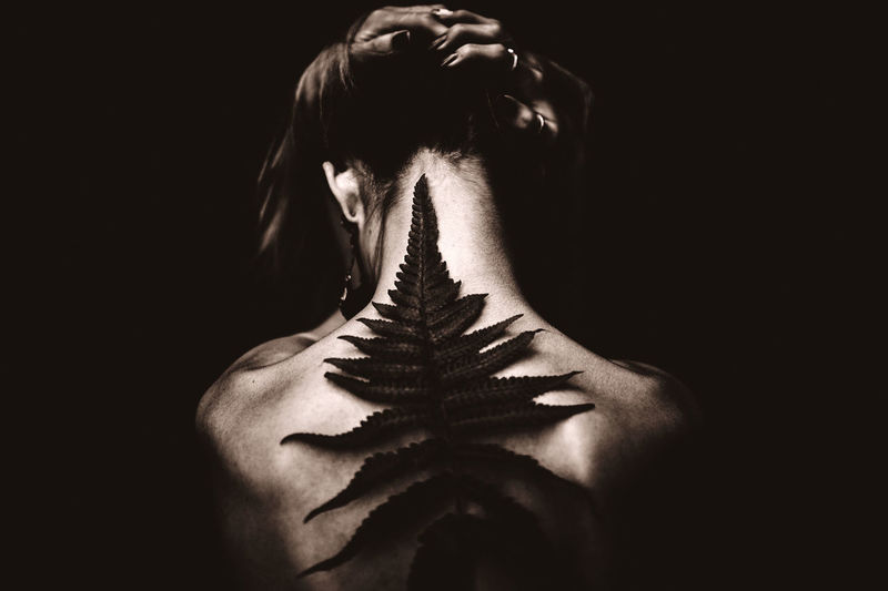 Close-up of woman against black background