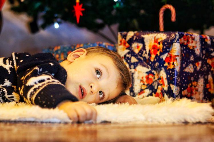 Boy lying on fur rug