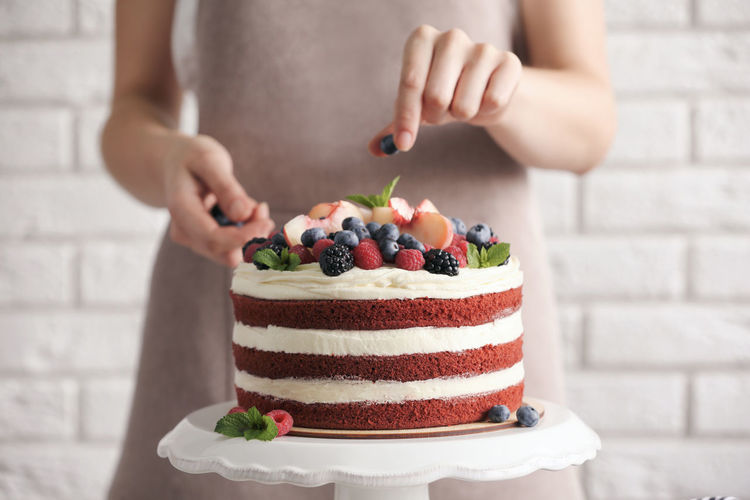 Midsection of woman holding cake