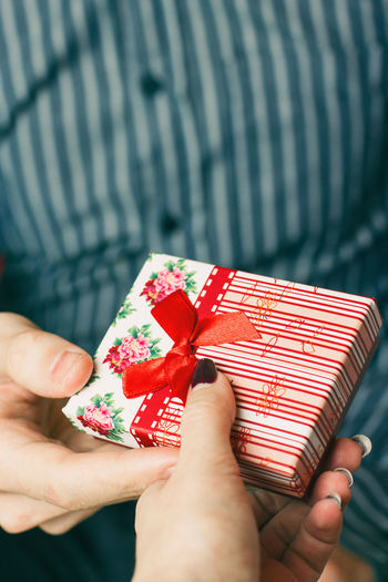 Cropped hand giving gift to man